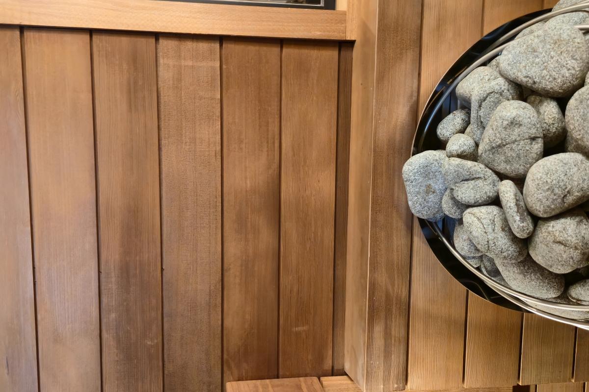 Sauna stones inside an electric heater against the wood-lined wall of a Turon indoor sauna.
