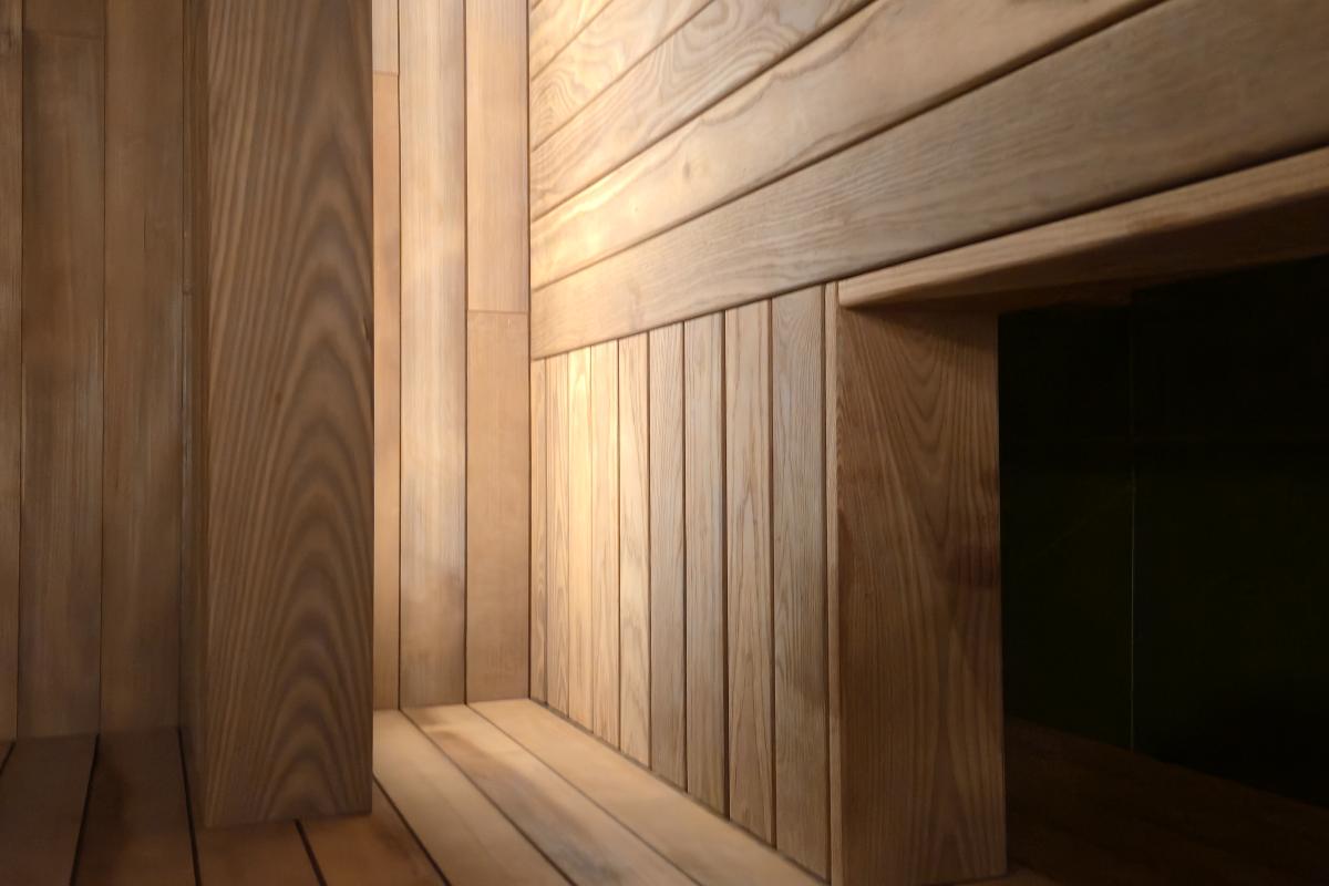 Warm concealed lighting beneath the wood benches in a Turon indoor sauna.
