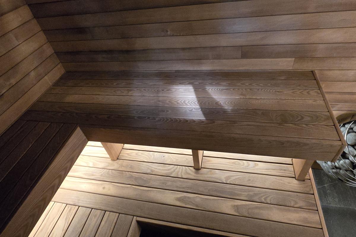 Custom wood benches, concealed lighting and a stone-filled electric heater in a completed Turon indoor sauna.