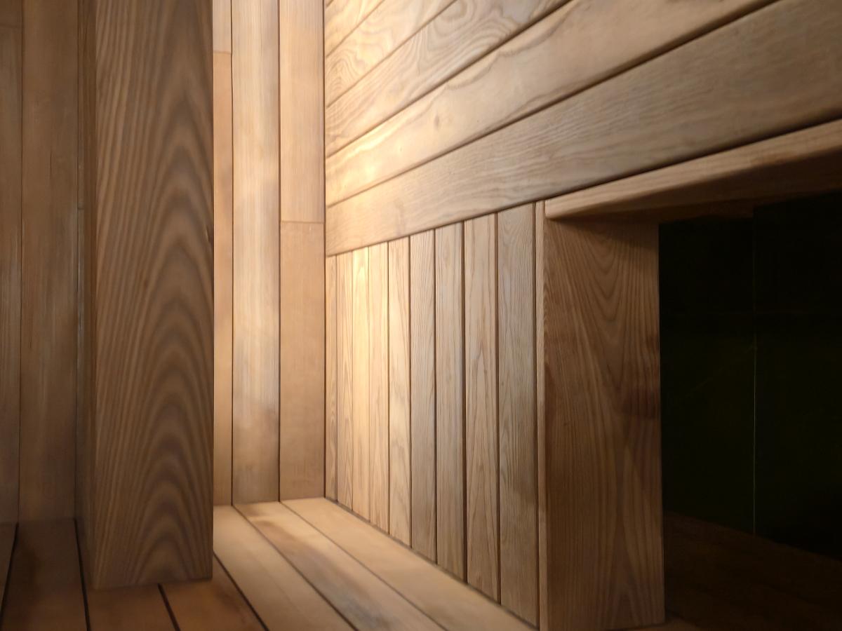 Warm concealed lighting beneath the wood benches in a Turon indoor sauna.