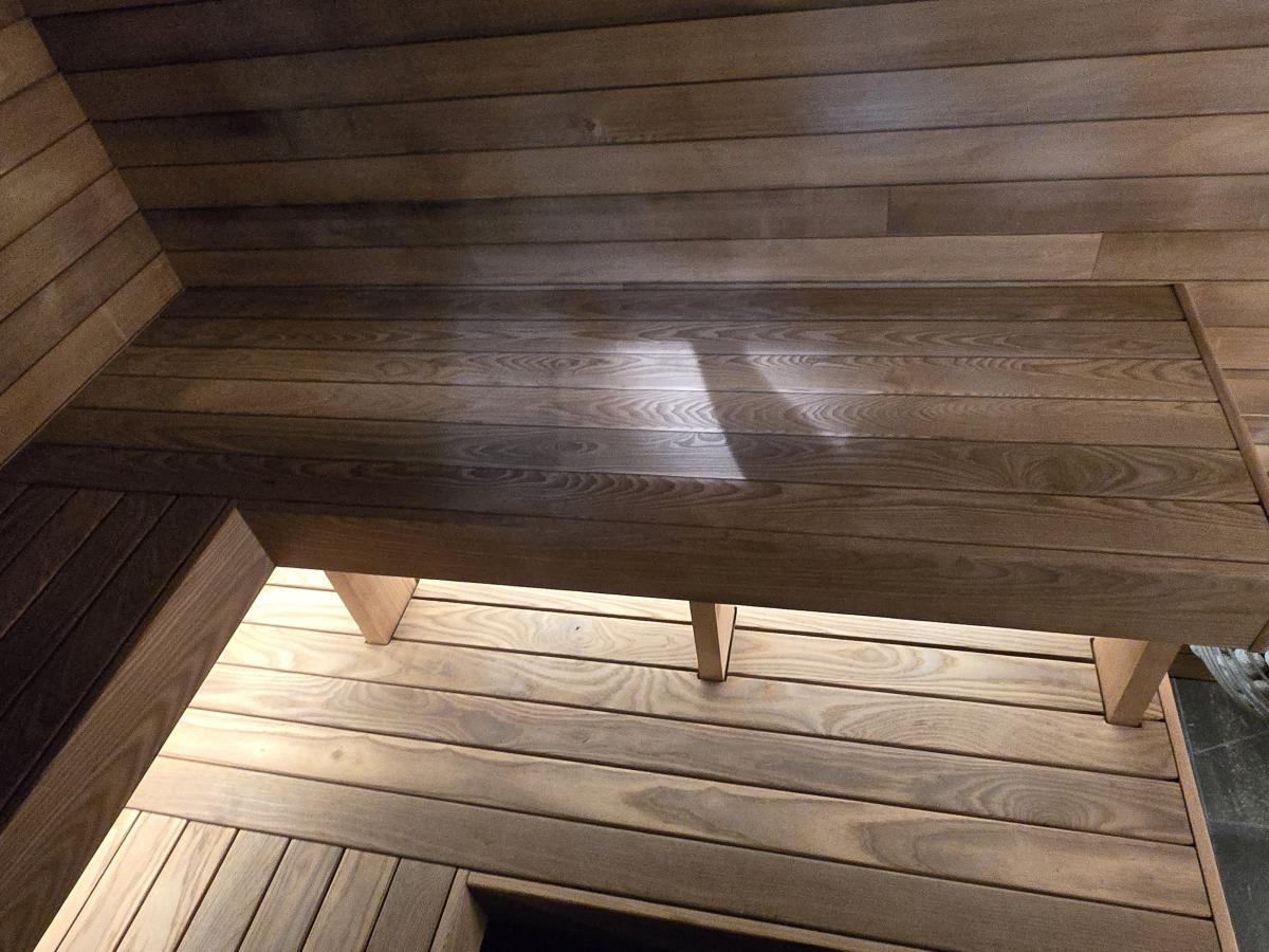 Custom wood benches, concealed lighting and a stone-filled electric heater in a completed Turon indoor sauna.