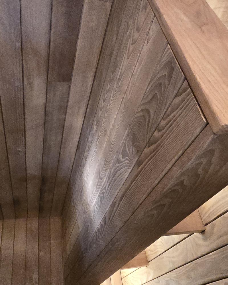 Close-up of the upper and lower wood benches and illuminated backrest in a Turon indoor sauna.
