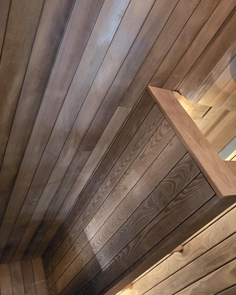 Interior of a completed Turon indoor sauna with wood benches, warm lighting and an electric sauna heater.